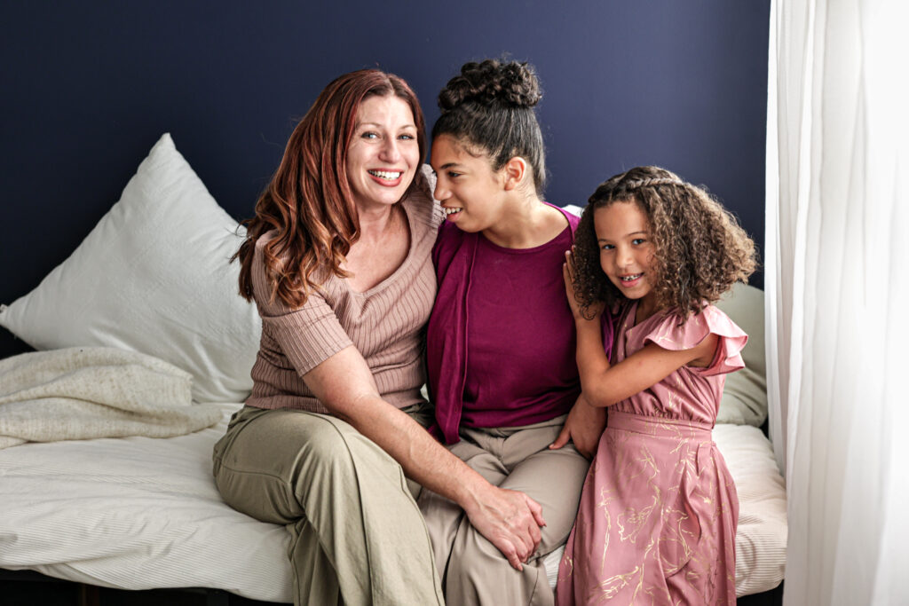 family portrait mother and daughters family photography navy blue backdrop natural lighting candid photo